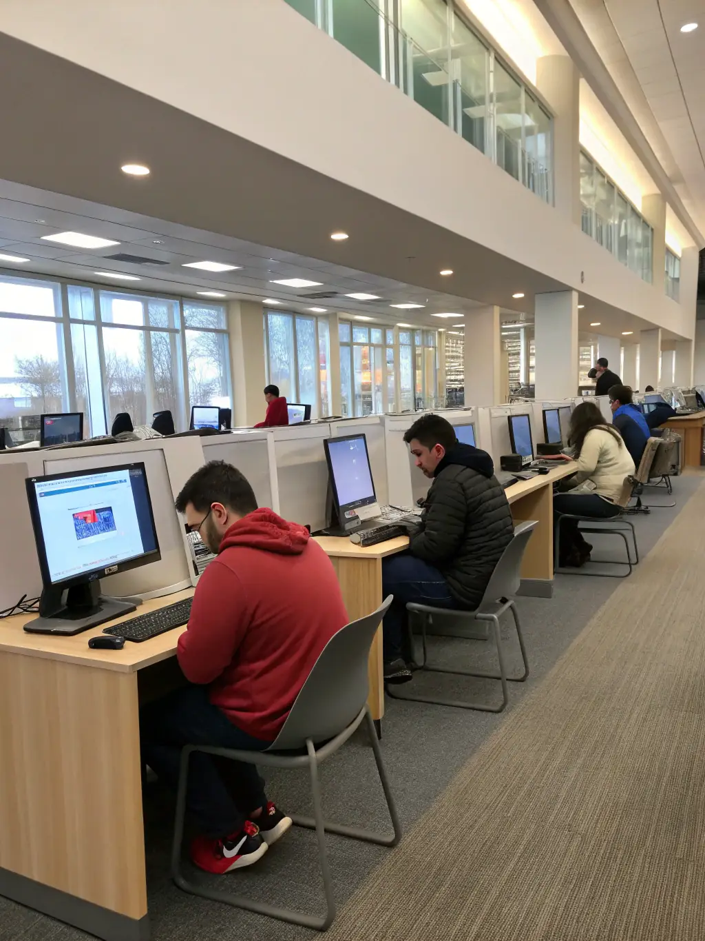 A diverse group of people accessing digitized historical archives on computers in a public library, emphasizing ONVIT's commitment to accessibility.